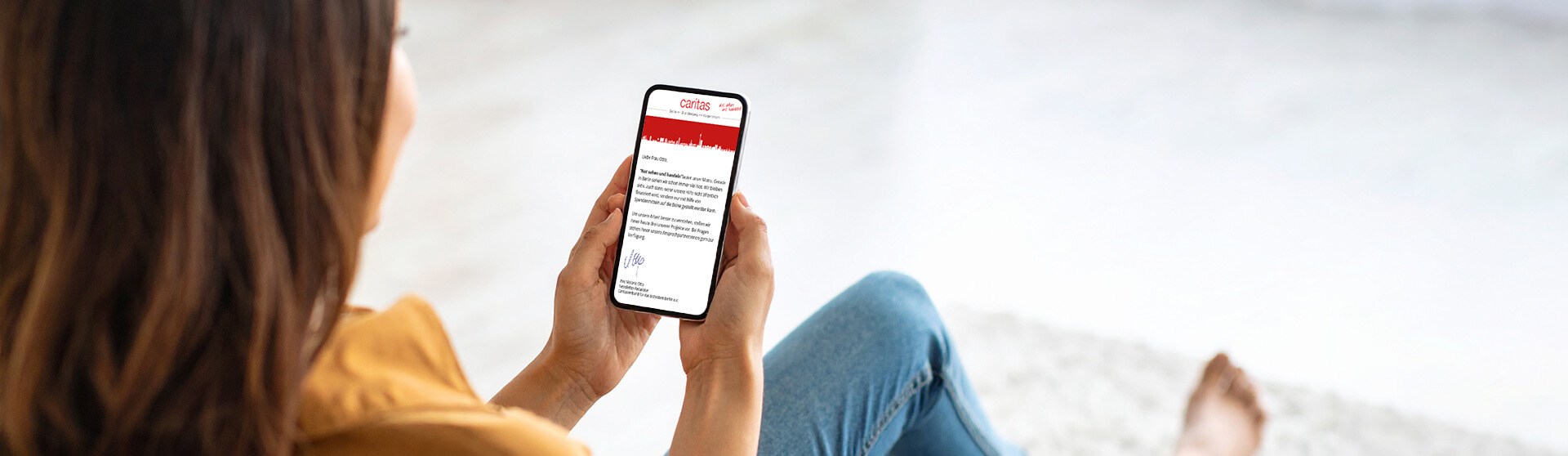 Frau liest Newsletter auf dem Smartphone