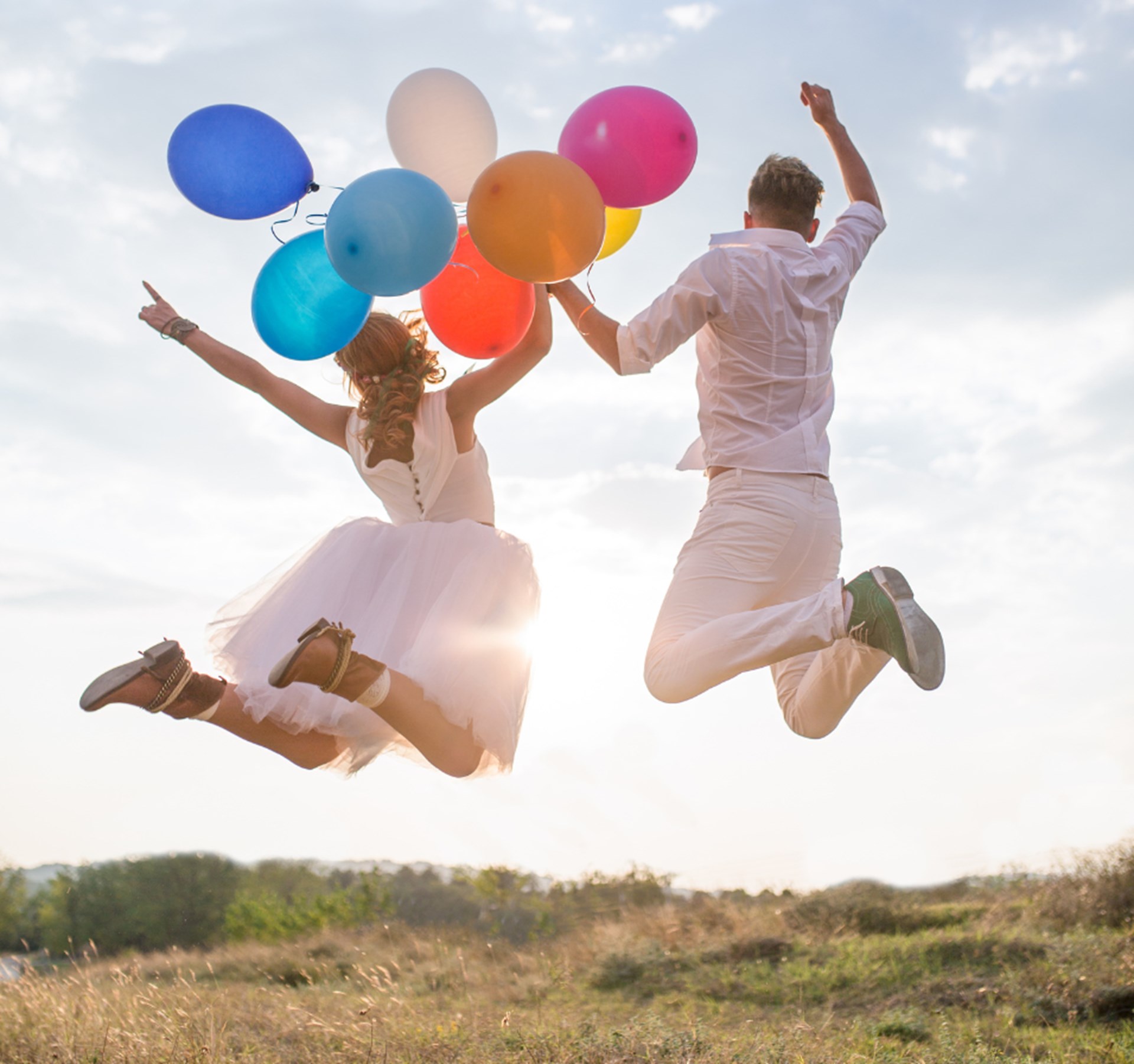 frisch Verheiratete mit bunten Luftballons in der Hand